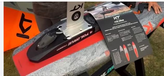 Kiteboard with KT logo and product information card on a grassy background